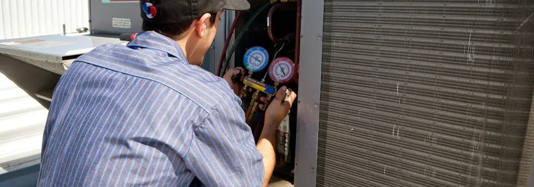 HVAC technician servicing a condenser unit in Albemarle