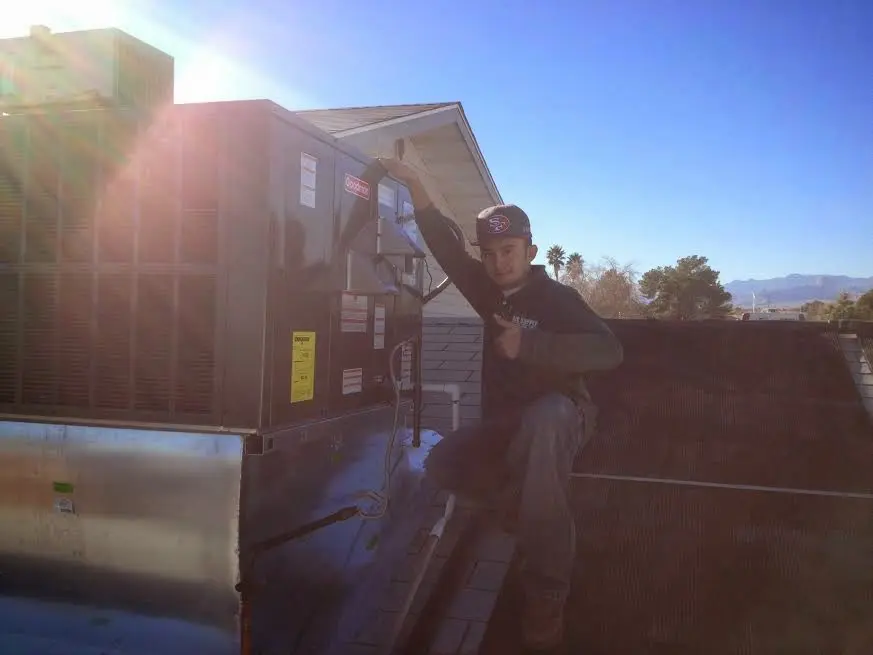 HVAC technician performing HVAC Inspection on a rooftop unit in Albemarle